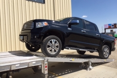 Pickup truck inclined on trailer ramp in Williston, ND