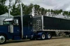 Black trailer on blue semi-truck, second view from the front