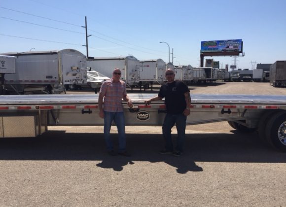 Two Men Standing in Front of Trailer at a Trailer Dealer Store  in Grand Forks, Fargo, ND, Williston, Minot, Bismarck, ND